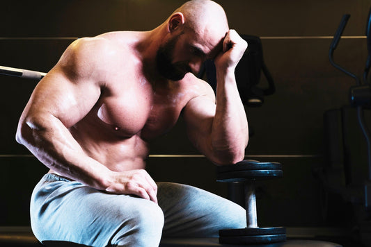Muscular lifter resting between sets during a gym workout